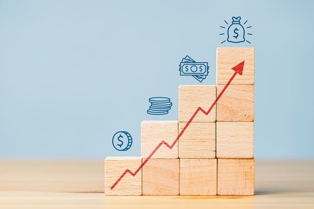 Block with an arrow pointing up and different money graphics