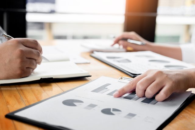 Business people looking at graphs on a clipboard