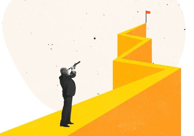 Businessman looking to top of the mountain that has a red flag