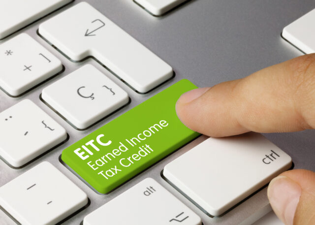 The words earned income tax credit written on a green key on a computer keyboard