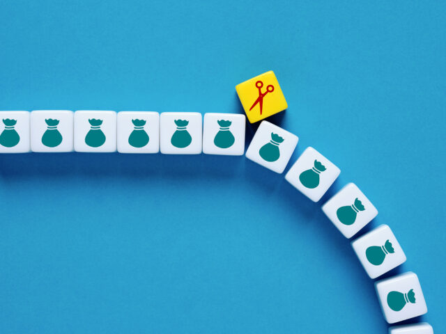 White cubes with money icon going down in a line with a yellow cube with a scissors icon in the middle